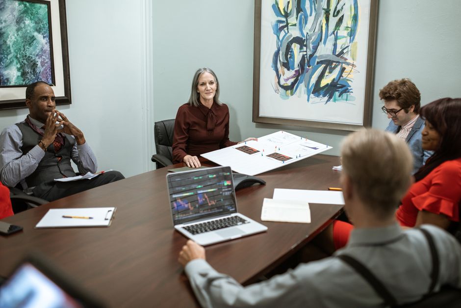 A group of professionals engaged in a business meeting around a conference table.